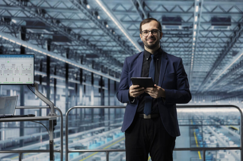 Operator korzysta z systemu MES na panelu dotykowym przy linii produkcyjnej